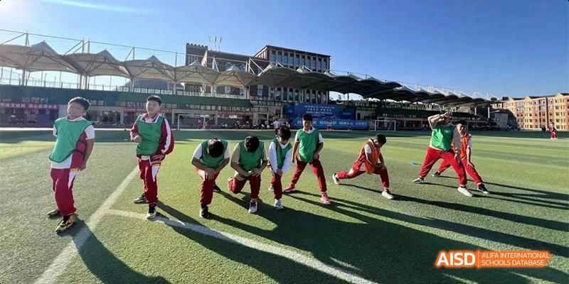 Guiyang Prime School students in uniform doing outdoor physical training or exercise on the school grounds, with the main building in the background.
