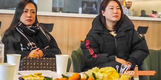 Guiyang Prime School staff or parents seated at a table with snacks and drinks during a meeting or informal gathering.