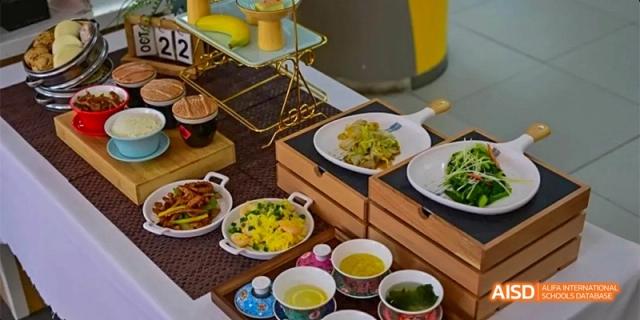 An elegant buffet spread features various small plates of stir-fry, noodles, and soup served on tiered wooden stands at Beijing Haidian Kaiwen Academy.