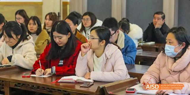 Two female students at Hangzhou World Foreign Language School are looking at a tablet in a classroom.