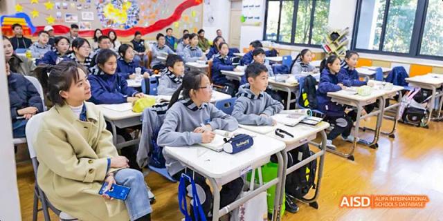A classroom full of students at Hangzhou World Foreign Language School is sitting at their desks, taking notes.