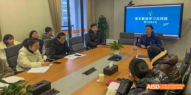 Two students from Hangzhou World Foreign Language School are sitting at a table in a meeting room.