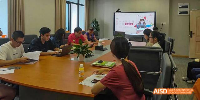 A group of students at Hangzhou World Foreign Language School are sitting around a table and having a discussion.