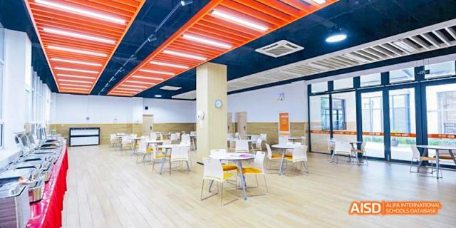 A clean, well-lit dining hall with modern tables and chairs at Hangzhou World Foreign Language School.
