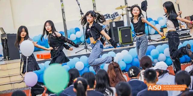 A female student at Hangzhou World Foreign Language School is performing a high-energy jump on a stage during an event.