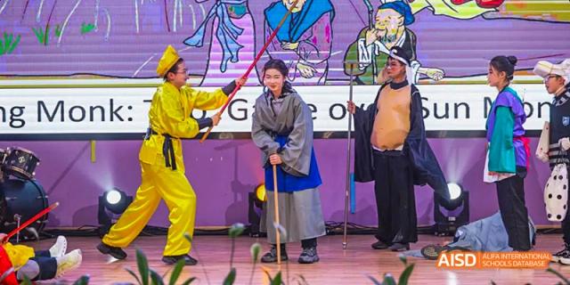 A person in traditional clothing is participating in a game at an event at Hangzhou World Foreign Language School.