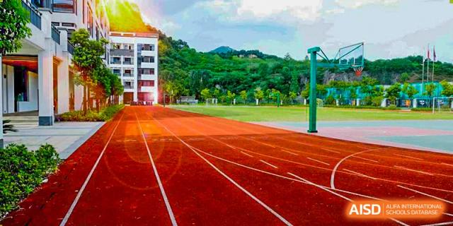 A red running track on the sports field at Hangzhou World Foreign Language School.