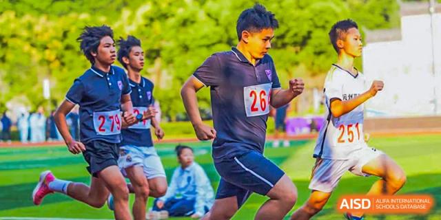 A student from Hangzhou World Foreign Language School wearing a number 26 shirt is running on a field.