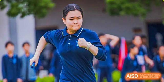 A female student from Hangzhou World Foreign Language School is running on a sports field.