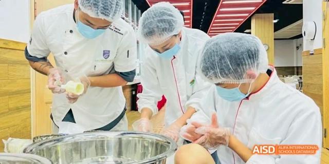 Two students in a kitchen at Hangzhou World Foreign Language School are preparing food.