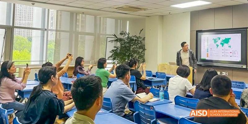 Students in a bright classroom raise their hands and participate during a dynamic lecture featuring a guest speaker at Hefei No.8 High School.
