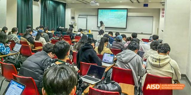 A wide shot of a crowded classroom where students are using laptops and taking notes during a technology-integrated lecture at Hefei No.8 High School.