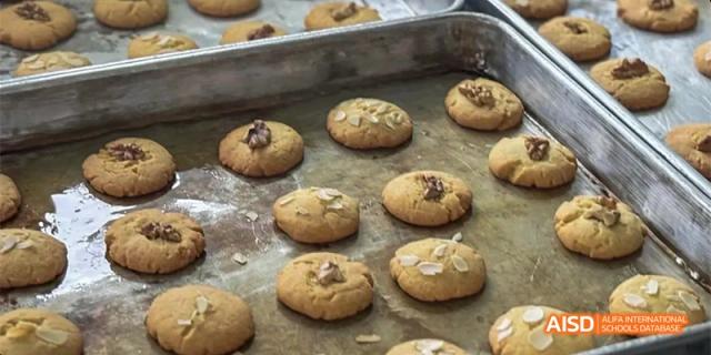 Freshly baked round cookies topped with nuts sitting on a metal baking sheet at Hefei No.8 High School.