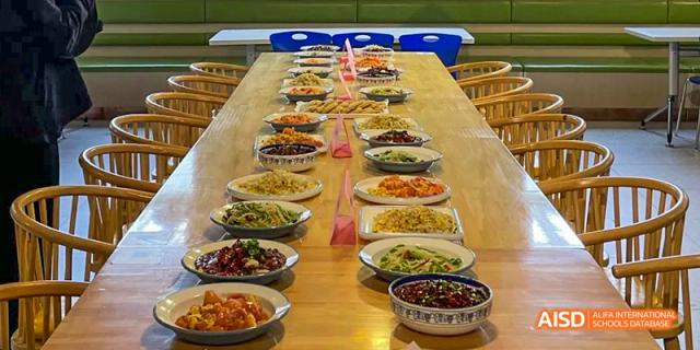 An overhead view of a long table lined with two rows of diverse Chinese dishes at Hefei No.8 High School.