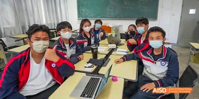 Students from Kunming No.1 High School International Education work on laptops at their desks in a classroom setting.