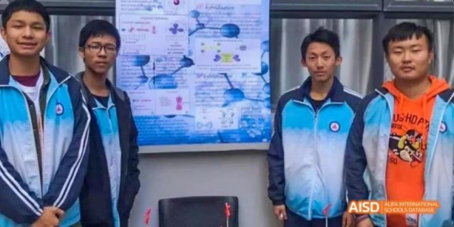 Two students from Kunming No.1 High School International Education stand in front of a diagram or chart, possibly in a science class.