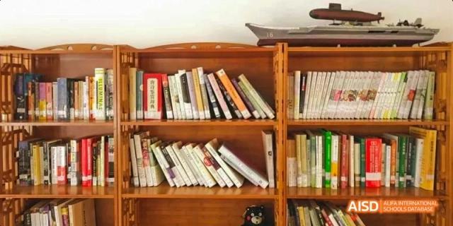 A wooden bookshelf at Kunming No.1 High School International Education filled with a variety of books.