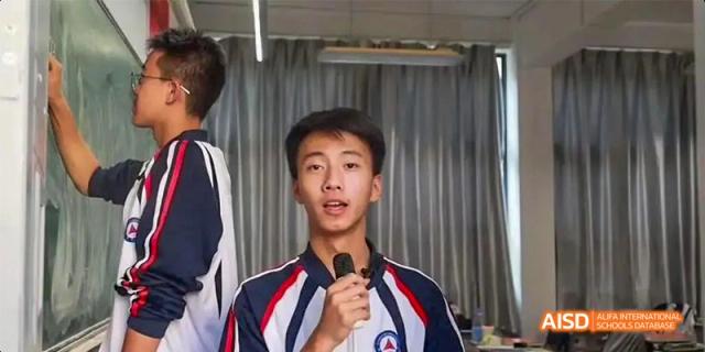 A portrait of a male student from Kunming No.1 High School International Education speaking into a microphone, with a slight variation in expression from the previous image.
