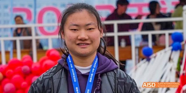 A close-up portrait of a female student from Kunming No.1 High School International Education smiling for the camera.