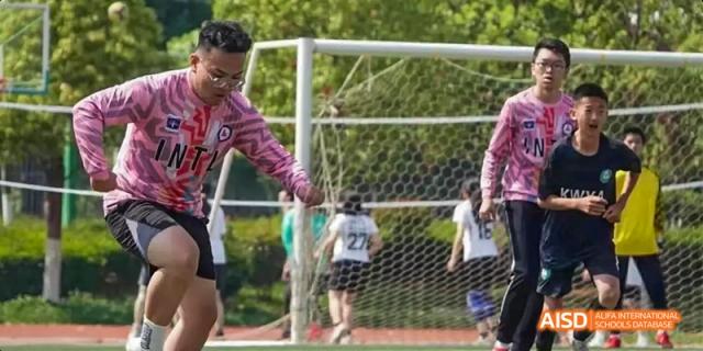 A student from Kunming No.1 High School International Education is playing soccer in front of a goal during a sports activity.