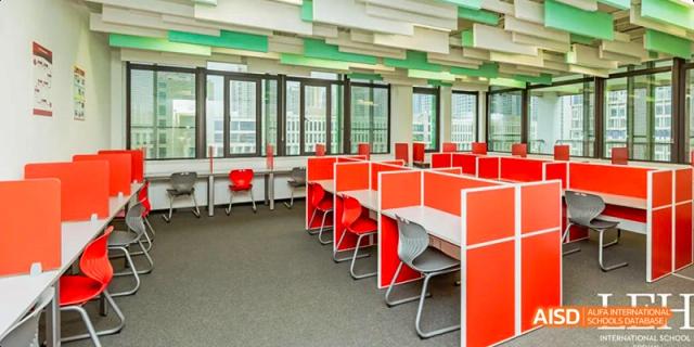 A modern study hall or library at Lady Eleanor Holles International School Foshan (LEH Foshan) with individual red study carrels.