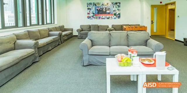 A comfortable student lounge area at Lady Eleanor Holles International School Foshan (LEH Foshan) with a large gray sofa and a coffee table.