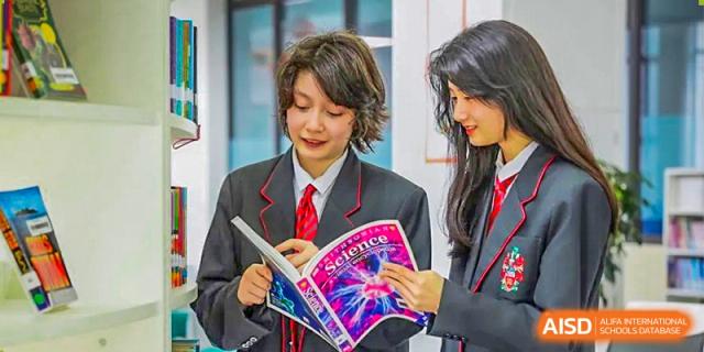 A student from Lady Eleanor Holles International School Foshan (LEH Foshan) in a school uniform reads a book in a classroom.