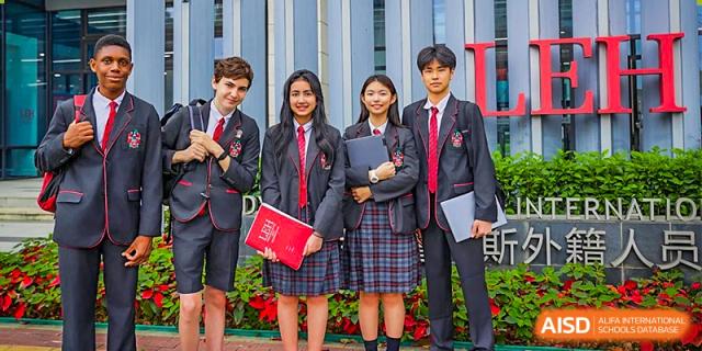 A group of students from Lady Eleanor Holles International School Foshan (LEH Foshan) in school uniforms stand together in a hallway.