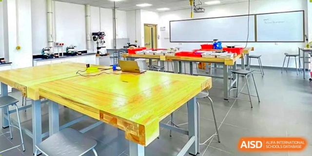 A science or design classroom at Lady Eleanor Holles International School Foshan (LEH Foshan) with a large yellow workbench in the center.
