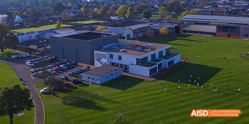An aerial view of the modern, white school buildings and the well-maintained green lawn at Lady Eleanor Holles International School Foshan(LEH Foshan).
