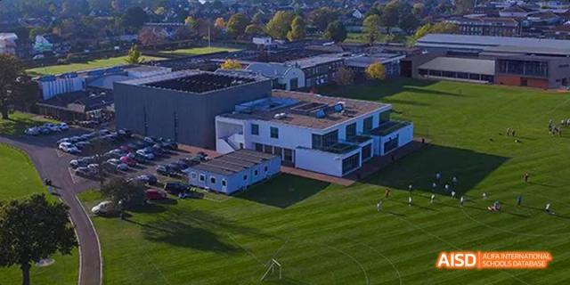 An aerial view of the modern, white school buildings and the well-maintained green lawn at Lady Eleanor Holles International School Foshan(LEH Foshan).