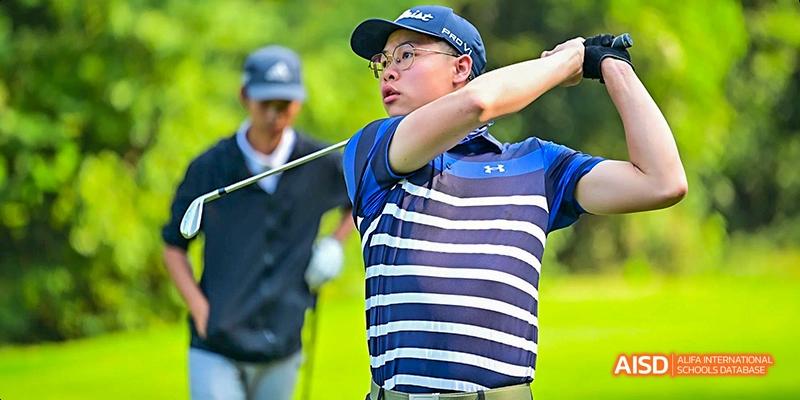 A student from Lady Eleanor Holles International School Foshan(LEH Foshan) in a polo shirt and cap playing golf.