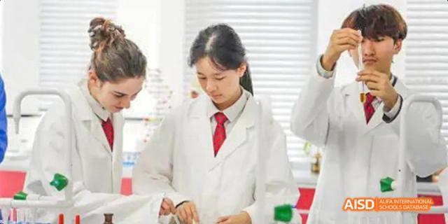A female student from Lady Eleanor Holles International School Foshan(LEH Foshan) wearing a lab coat and red tie, working on a science experiment.