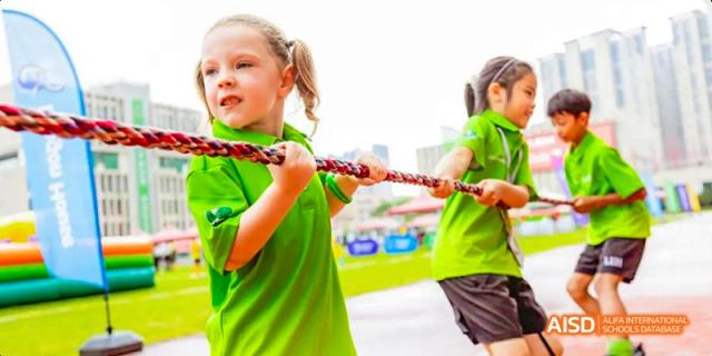 A team of students from Lady Eleanor Holles International School Foshan (LEH Foshan) in green t-shirts playing tug-of-war.