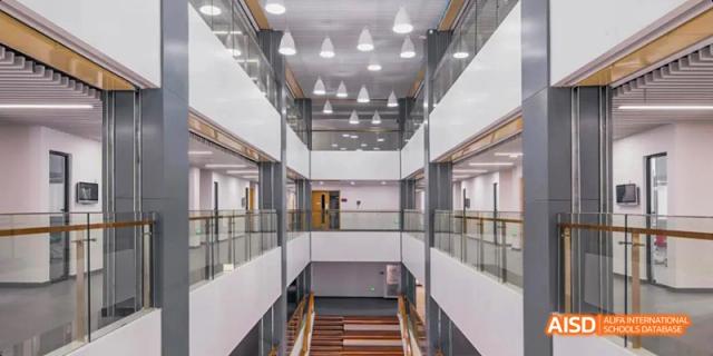 An interior view of a modern building at Lady Eleanor Holles International School Foshan (LEH Foshan) with a high ceiling and multi-story open space.
