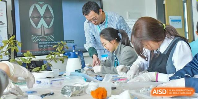 A teacher from Nord Anglia School Guangzhou Panyu assisting a student with a science experiment.
