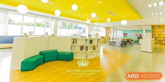 The bright, yellow-themed library at Nord Anglia School Guangzhou Panyu with the school logo on the wall.