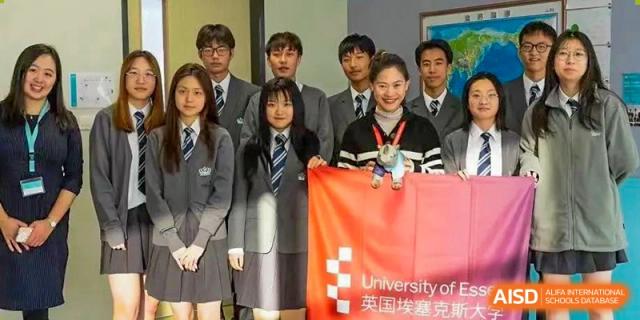 A group of students from Nord Anglia School Guangzhou Panyu holding a "University of Oxford" banner at a school event.