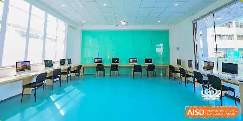 An empty computer lab with a bright turquoise wall at Nord Anglia School Guangzhou Panyu.