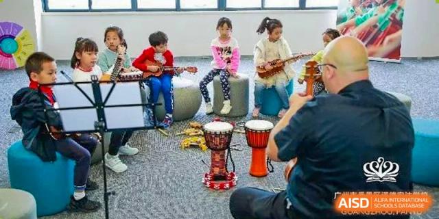 Young students from Nord Anglia School Guangzhou Panyu playing musical instruments in a classroom.