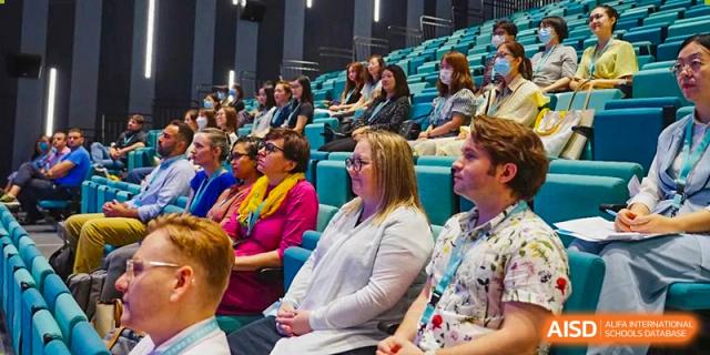 A group of people, including parents and staff from Nord Anglia School Guangzhou Panyu, seated and attending a school event.