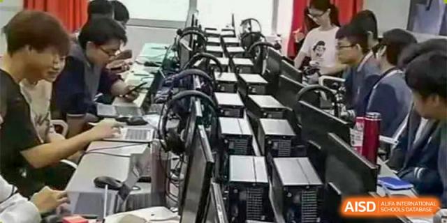 A row of computer towers and monitors in a server room or technology lab at Orange County American High School Beijing Campus.