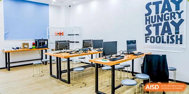 A clean, modern computer lab with individual workstations and monitors set up for student use at Orange County American High School Beijing Campus.