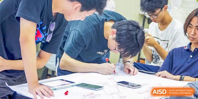 A male student sketching or drawing during a design or architecture class at Orange County American High School Beijing Campus.
