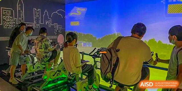 A student exercising indoors on a stationary bike or elliptical machine at Orange County American High School Beijing Campus.