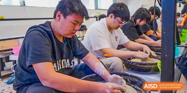 A close-up of a student working with clay during an art or ceramics class at Orange County American High School Beijing Campus.
