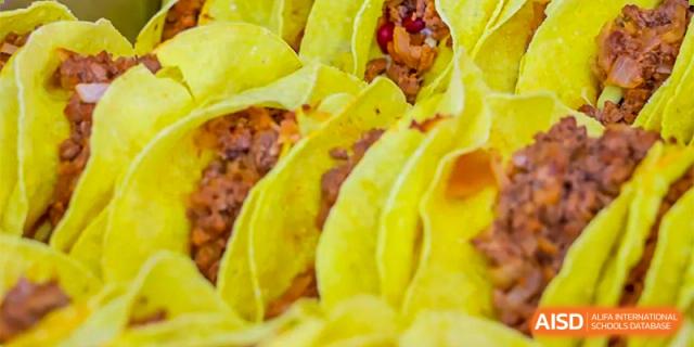 A close-up of a serving tray of yellow savory pastries or corn-based food available in the cafeteria at Oriental Cambridge International School.