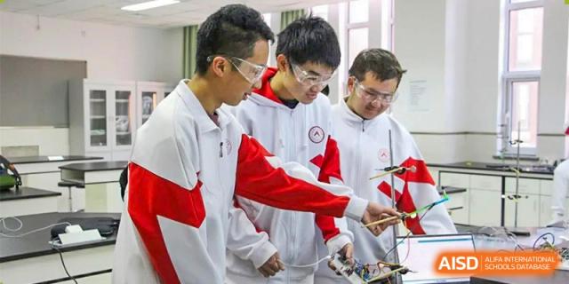 Two students from RCF Experimental School in uniform working together on a project.