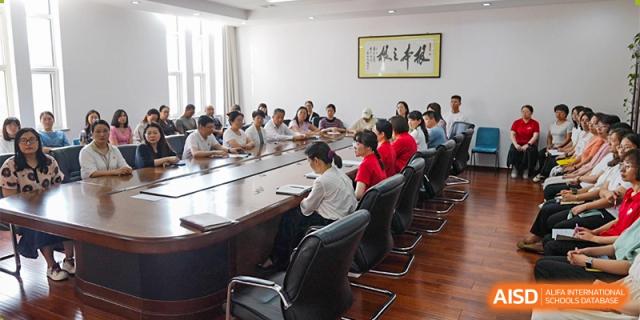 Adults and teachers from RCF Experimental School sitting at a long table for a meeting.