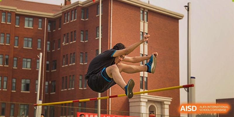 A high-school student from RCF Experimental School in mid-air during a high jump event.